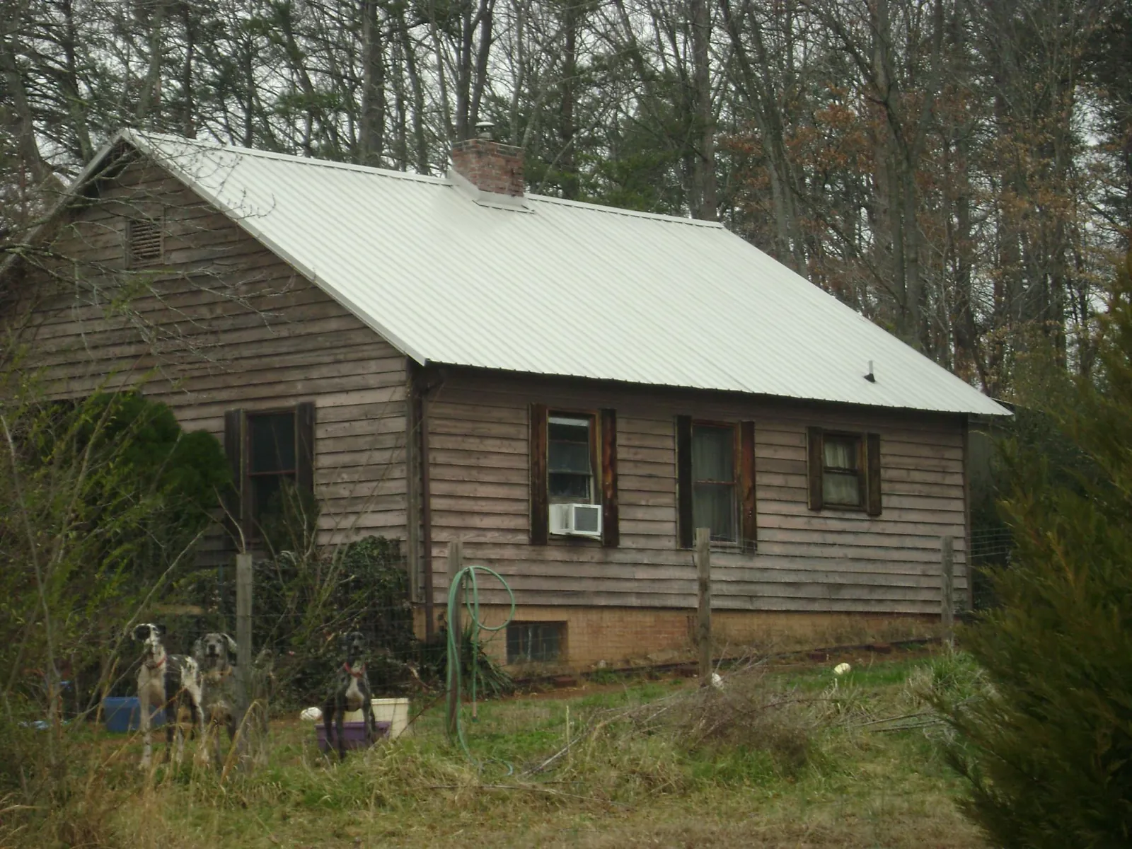White metal roof on an old wood sided farmhouse, from a Metal Roof Installation job in Springfield